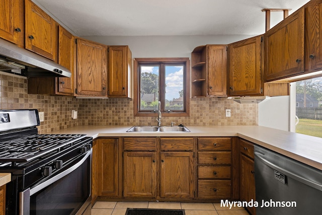 602 Elsa St, North Muskegon, MI 49445 - kitchen with stainless steel appliances, under cabinet range hood, light countertops, and light tile patterned flooring