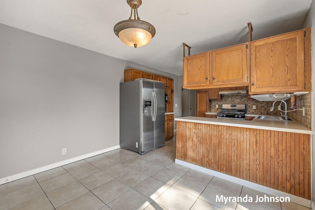 602 Elsa St, North Muskegon, MI 49445 - kitchen with stainless steel appliances, under cabinet range hood, tasteful backsplash, a peninsula, and light countertops