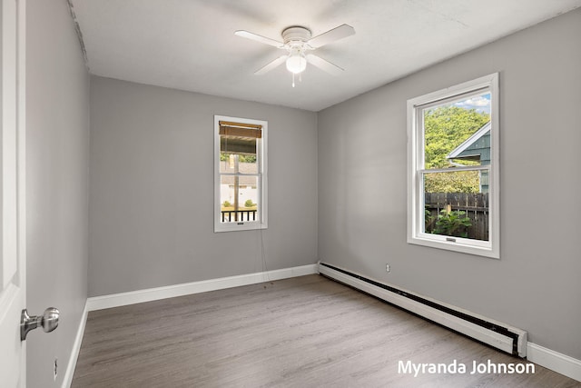 602 Elsa St, North Muskegon, MI 49445 - empty room with a baseboard radiator, plenty of natural light, and wood finished floors