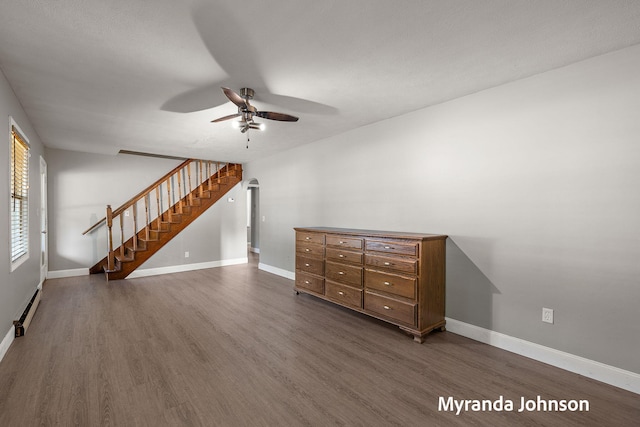 602 Elsa St, North Muskegon, MI 49445 - unfurnished living room with ceiling fan, dark wood-style floors, baseboard heating, and stairway