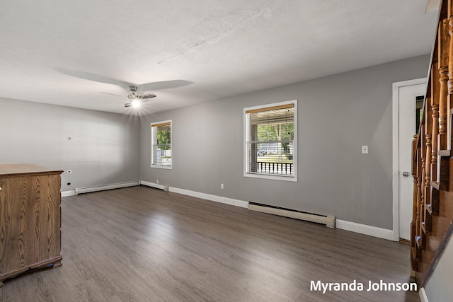 602 Elsa St, North Muskegon, MI 49445 - unfurnished living room featuring baseboard heating, dark wood finished floors, and a ceiling fan