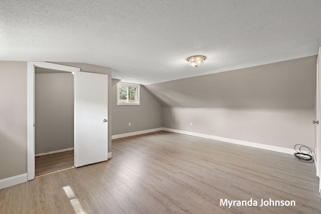 602 Elsa St, North Muskegon, MI 49445 - additional living space featuring wood finished floors, a textured ceiling, and lofted ceiling
