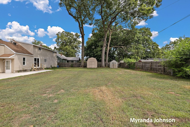 602 Elsa St, North Muskegon, MI 49445 - fenced backyard with a storage shed, entry steps, and a patio area