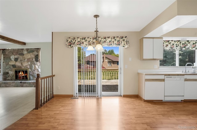 822 Keaton Dr, Troy, MI 48098 - unfurnished dining area with light wood-style floors, a chandelier, and a stone fireplace