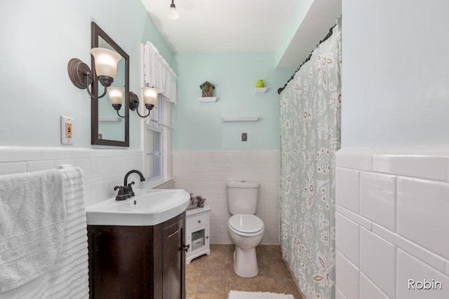 119 Bristol Ave NW, Grand Rapids, MI 49504 - full bathroom with tile walls, vanity, wainscoting, and tile patterned floors