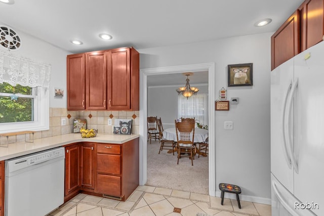 119 Bristol Ave NW, Grand Rapids, MI 49504 - kitchen featuring white appliances, light countertops, tasteful backsplash, light carpet, and a chandelier