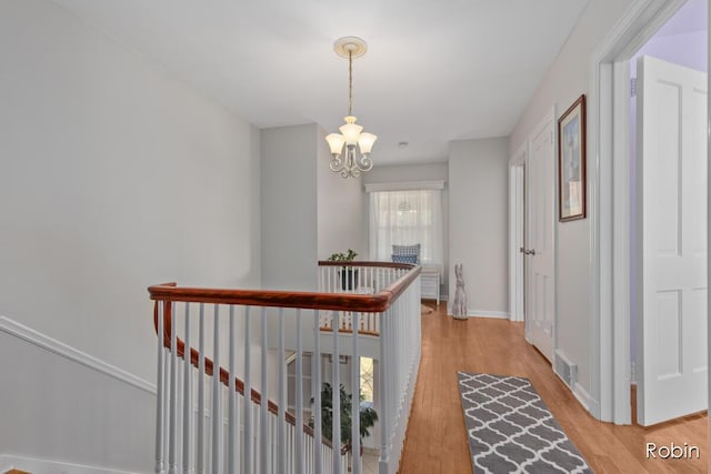 119 Bristol Ave NW, Grand Rapids, MI 49504 - corridor featuring an upstairs landing, a chandelier, and light wood-style floors