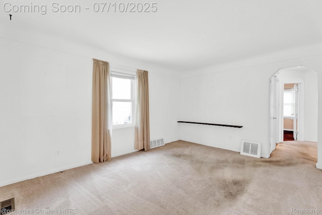 816 E 3rd St, Royal Oak, MI 48067 - carpeted empty room with arched walkways and healthy amount of natural light