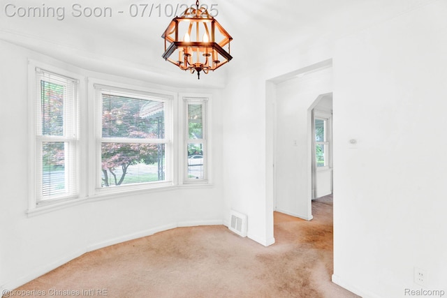 816 E 3rd St, Royal Oak, MI 48067 - spare room with healthy amount of natural light, light colored carpet, arched walkways, and a chandelier