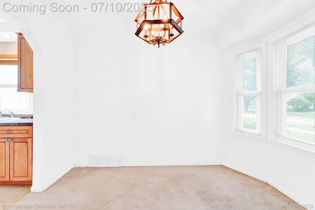 816 E 3rd St, Royal Oak, MI 48067 - unfurnished dining area with light carpet, a chandelier, and arched walkways