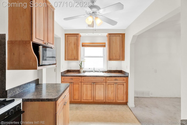 816 E 3rd St, Royal Oak, MI 48067 - kitchen with stainless steel microwave, dark countertops, range, a ceiling fan, and light colored carpet