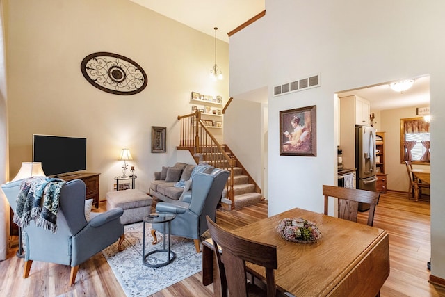 9379 Jamie Dr, Davison, MI 48423 - living room featuring light wood-type flooring, stairway, and a towering ceiling