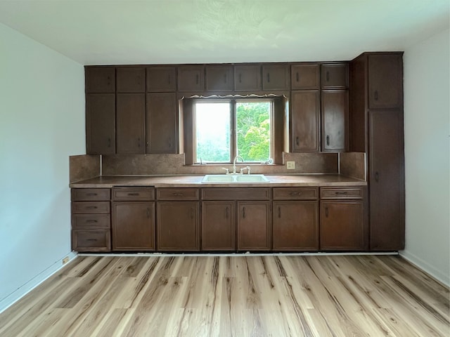 2839 128th Ave, Holland, MI 49424 - kitchen featuring light wood-type flooring, light countertops, tasteful backsplash, and dark brown cabinetry
