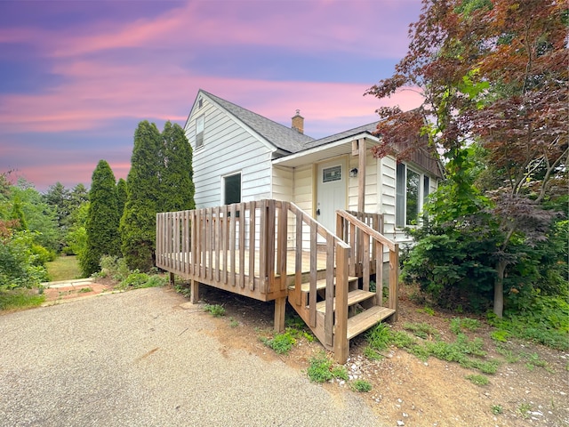 2839 128th Ave, Holland, MI 49424 - view of front of house with a chimney, a deck, and a shingled roof