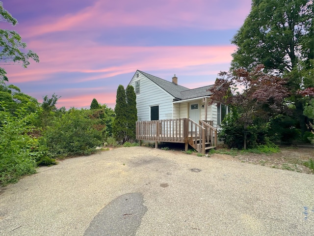 2839 128th Ave, Holland, MI 49424 - view of front of property featuring a chimney, a shingled roof, and a deck