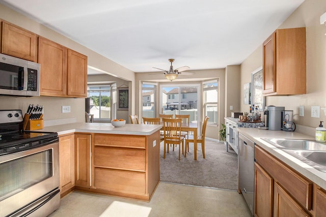 8767 Lilly Dr, Ypsilanti, MI 48197 - kitchen featuring appliances with stainless steel finishes, a peninsula, light countertops, and ceiling fan