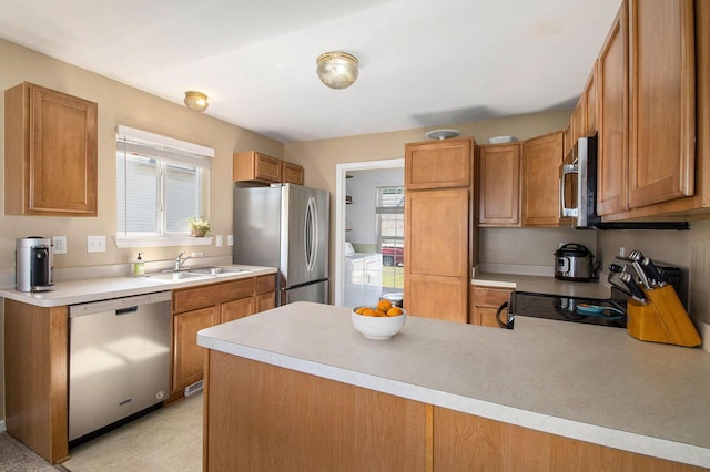 8767 Lilly Dr, Ypsilanti, MI 48197 - kitchen with stainless steel appliances, washing machine and clothes dryer, healthy amount of natural light, and light countertops