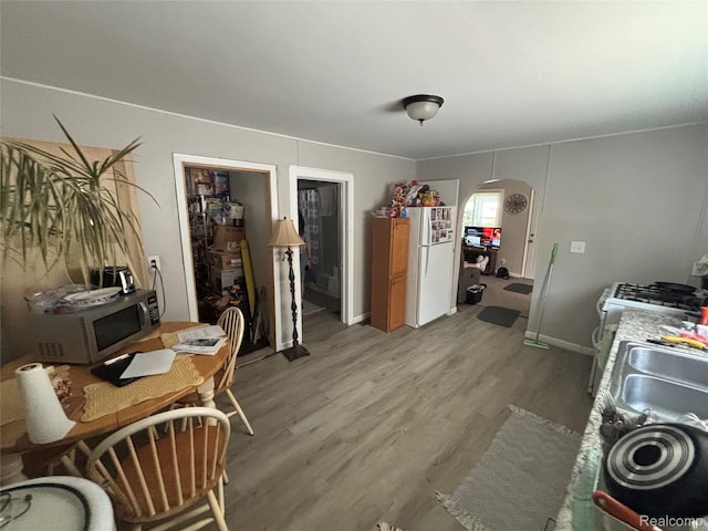 130 Meadle St, Warren, MI 48043 - dining space featuring arched walkways and light wood finished floors