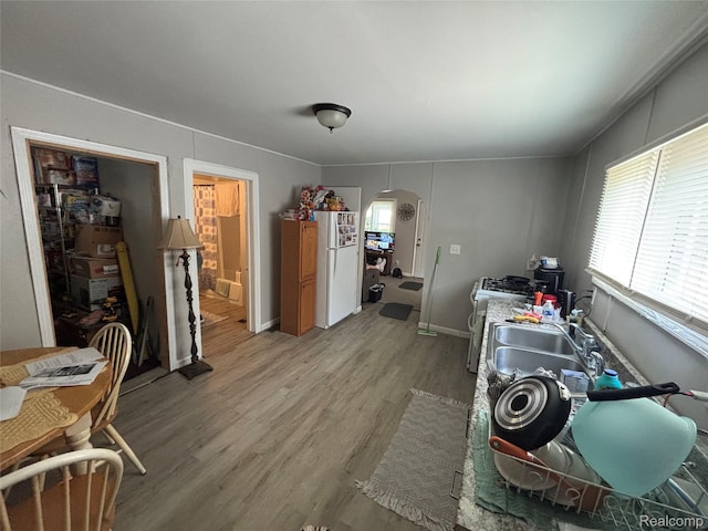 130 Meadle St, Warren, MI 48043 - kitchen featuring arched walkways, freestanding refrigerator, and light wood finished floors