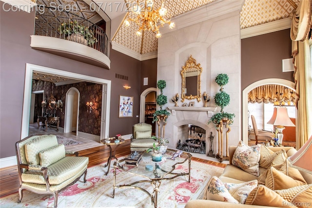 2756 Turtle Bluff Dr, Bloomfield Hills, MI 48302 - living room with a high ceiling, arched walkways, a premium fireplace, a chandelier, and wood finished floors