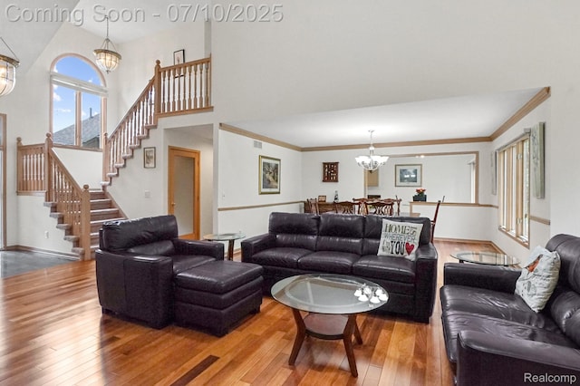 4253 Drexel Dr, Troy, MI 48098 - living room with a chandelier, hardwood / wood-style flooring, stairway, crown molding, and a towering ceiling