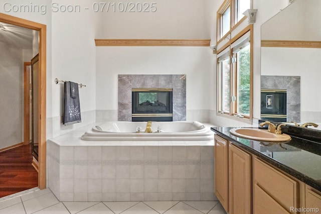 4253 Drexel Dr, Troy, MI 48098 - bathroom with a tiled fireplace, tile patterned floors, vanity, and a garden tub