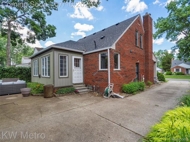 1877 Wiltshire Rd, Berkley, MI 48072 - rear view of house with entry steps, a shingled roof, brick siding, a chimney, and an outdoor living space