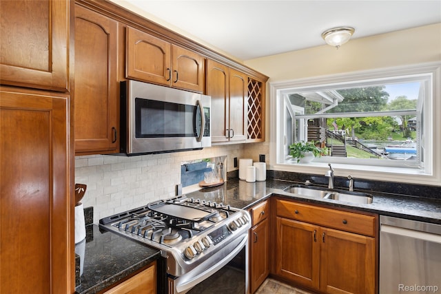 2009 Ridge Rd, White Lake, MI 48383 - kitchen featuring stainless steel appliances, tasteful backsplash, dark stone countertops, and brown cabinetry