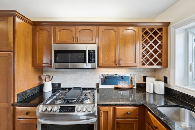 2009 Ridge Rd, White Lake, MI 48383 - kitchen with stainless steel appliances, brown cabinetry, tasteful backsplash, and dark stone countertops