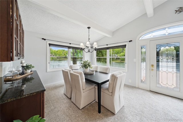 2009 Ridge Rd, White Lake, MI 48383 - dining area featuring light carpet, a chandelier, a textured ceiling, and a water view