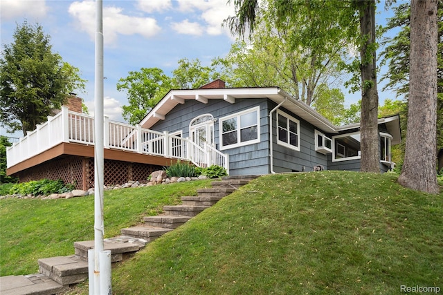 2009 Ridge Rd, White Lake, MI 48383 - view of front of house featuring a deck, a front yard, and a chimney