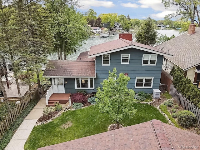 2009 Ridge Rd, White Lake, MI 48383 - back of property featuring a chimney, a fenced backyard, and a shingled roof