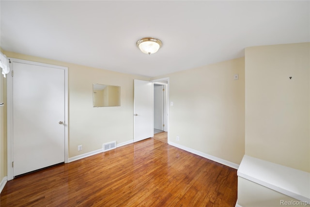 2009 Ridge Rd, White Lake, MI 48383 - unfurnished bedroom with wood finished floors and baseboards