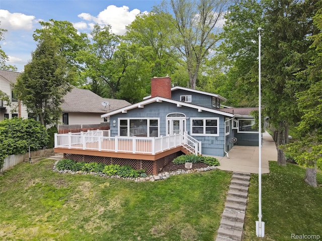 2009 Ridge Rd, White Lake, MI 48383 - back of house featuring a chimney, a yard, and a deck