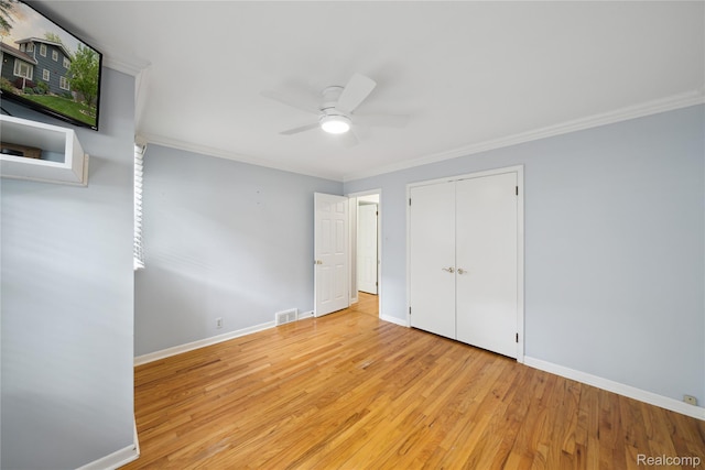 2009 Ridge Rd, White Lake, MI 48383 - unfurnished bedroom featuring crown molding, wood finished floors, a closet, and ceiling fan