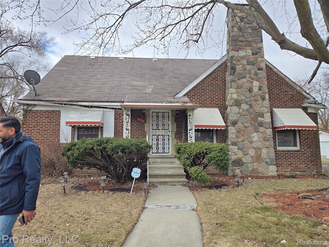 17211 Monica St, Detroit, MI 48221 - tudor house featuring a chimney, brick siding, and a shingled roof