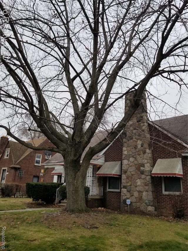 17211 Monica St, Detroit, MI 48221 - view of side of property featuring a chimney, brick siding, and a lawn