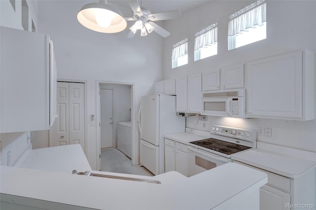 37306 Amhurst Dr, Westland, MI 48185 - kitchen featuring white appliances, a towering ceiling, ceiling fan, separate washer and dryer, and white cabinetry