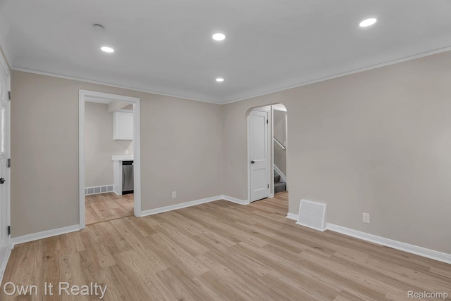1389 Cleveland Ave, Northville, MI 48146 - spare room featuring crown molding, arched walkways, light wood-type flooring, stairway, and recessed lighting