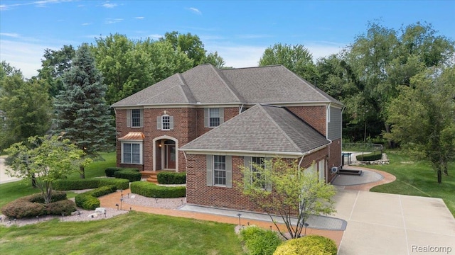 8507 Newbury Ct N, Canton, MI 48187 - colonial-style house with driveway, a front yard, brick siding, a shingled roof, and a garage