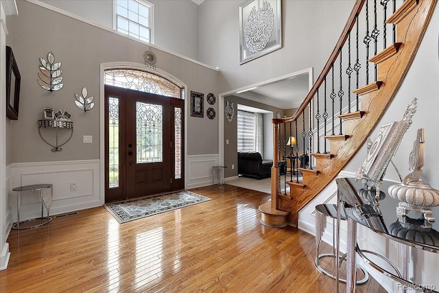 8507 Newbury Ct N, Canton, MI 48187 - foyer entrance with plenty of natural light, light wood-style floors, a high ceiling, a wainscoted wall, and stairs