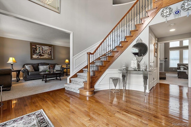 8507 Newbury Ct N, Canton, MI 48187 - stairs with a towering ceiling, wood-type flooring, crown molding, and a decorative wall