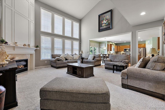 8507 Newbury Ct N, Canton, MI 48187 - living room with high vaulted ceiling, a fireplace, light carpet, and recessed lighting