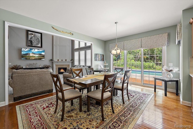 8507 Newbury Ct N, Canton, MI 48187 - dining room featuring a lit fireplace and light wood finished floors