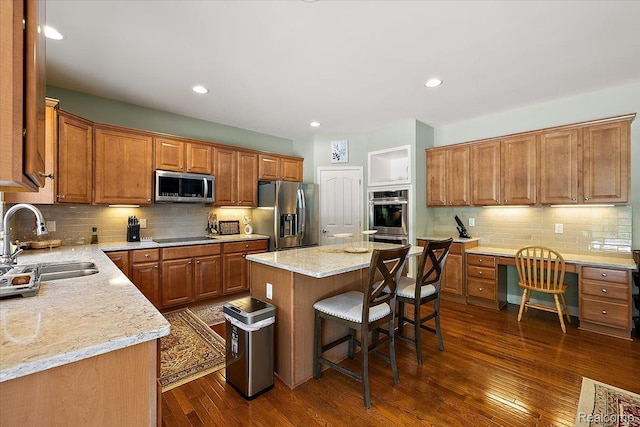 8507 Newbury Ct N, Canton, MI 48187 - kitchen with appliances with stainless steel finishes, tasteful backsplash, brown cabinetry, a kitchen island, and recessed lighting