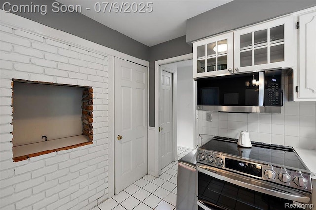 32010 Inglewood St, Franklin, MI 48025 - kitchen with stainless steel appliances, white cabinetry, decorative backsplash, light tile patterned floors, and glass insert cabinets