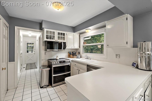 32010 Inglewood St, Franklin, MI 48025 - kitchen featuring stainless steel appliances, light tile patterned floors, white cabinetry, light countertops, and backsplash
