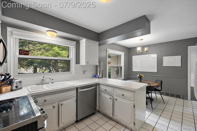32010 Inglewood St, Franklin, MI 48025 - kitchen with appliances with stainless steel finishes, a peninsula, white cabinets, light tile patterned floors, and light countertops