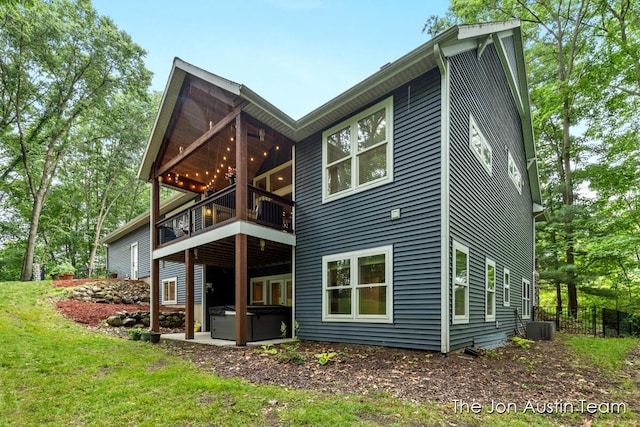 7979 Ella Terrace Dr, Rockford, MI 49341 - back of house featuring a hot tub, a balcony, and a lawn