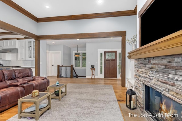 7979 Ella Terrace Dr, Rockford, MI 49341 - living room with crown molding, light wood-type flooring, recessed lighting, and a fireplace
